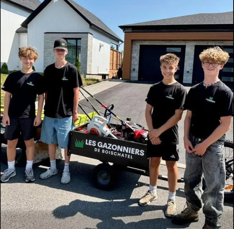 Quatre jeunes Gazonniers devant la remorque de l’entreprise
